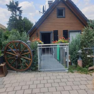 una casa de madera con una rueda de madera y una puerta en Ferienhof Kaiser, en Herrieden