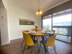 a dining room with a table and yellow chairs at בית הכרם in H̱azon
