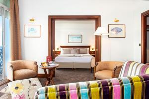 a hotel room with a bed and a couch at Hôtel West End Promenade in Nice