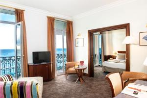 a hotel room with a bed and a view of the ocean at Hôtel West End Promenade in Nice