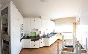 a kitchen with white cabinets and a sink at JALEPA in Muxia