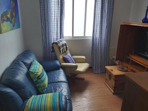 a living room with a blue couch and a chair at JALEPA in Muxia