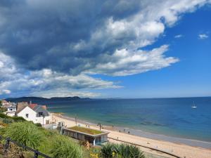 a view of a beach with a house and the ocean at The Linhay in Bridport