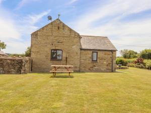 a picnic table in front of a stone building at The Cottage in Talacre