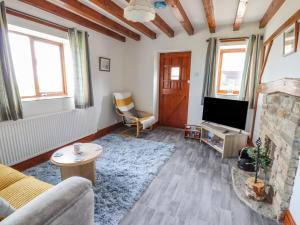a living room with a couch and a television at The Cottage in Talacre