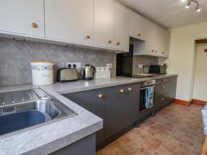 a kitchen with a sink and a counter top at The Cottage in Talacre