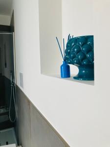 niebieska waza siedząca na półce w łazience w obiekcie La Casa al Gelso w mieście Rodi Garganico