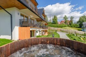 Tybet Domki i Apartamenty في بوكافينا تترايسكا: ميزة المياه في الفناء الخلفي للمنزل