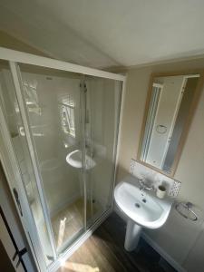 a bathroom with a glass shower and a sink at Two Bedroom Willerby Parkhome in Uddingston, Glasgow in Uddingston