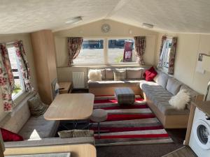 Two Bedroom Willerby Parkhome in Uddingston, Glasgow في أودينغستن: غرفة معيشة مع أريكة وطاولة