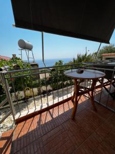 a table on a balcony with a view of the ocean at Emilios house in Dhërmi