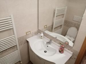 a white bathroom with a sink and a mirror at RESIDENZA CADORINA in Calalzo