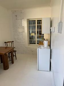 a kitchen with a refrigerator and a table and a window at Vyfster - Old Jail in Britstown