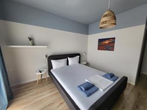 Un dormitorio con una cama con toallas azules. en Căsuța Sofiei en Eşelniţa