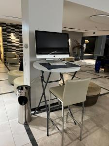 Cette chambre comprend un bureau avec un ordinateur et une chaise. dans l'établissement Hotel Floris Arlequin Grand-Place, à Bruxelles