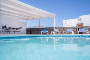 einen Pool mit Stühlen und einem Tisch in der Unterkunft VV Mapaluca MiniGolf by HH in Playa Blanca