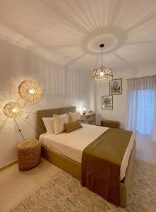 a bedroom with a large bed and two lights at Condominio Formosa Village in Fuzeta