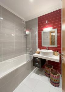 a bathroom with a white sink and a tub and a sink at Condominio Formosa Village in Fuzeta