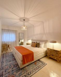 a bedroom with a large bed and a chandelier at Condominio Formosa Village in Fuzeta