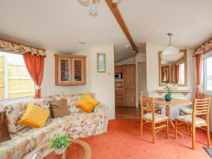 a living room with a couch and a table at Ty Newydd Caravan in Pwllheli