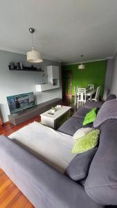 un soggiorno con un grande divano e una cucina di Piso céntrico en Pontevedra a Pontevedra