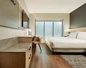 - une chambre avec un lit, un bureau et une fenêtre dans l'établissement Hyatt Place Toronto-Brampton, à Brampton