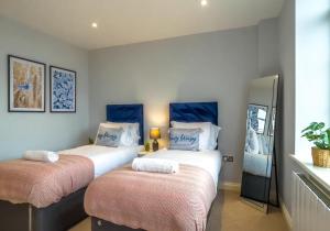 duas camas num quarto com azul e branco em Southern View 3 By My Getaways em Brighton & Hove