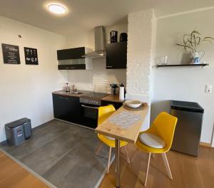 uma cozinha com uma mesa de madeira e cadeiras amarelas em Ferienwohnung "Boddenland" em Barth