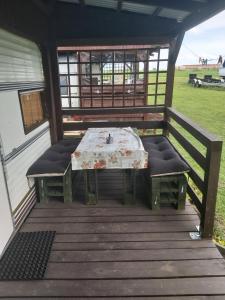 a table and two chairs on a deck at Kemping Pod Topolami in Górkło