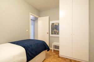 a bedroom with a bed and a large white cabinet at Midtown Rosalia in Vigo
