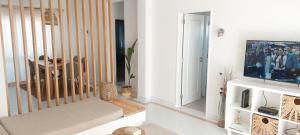een woonkamer met een televisie en een tafel bij Apartamento 90m2 com vista mar - Albufeira in Albufeira