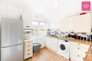 a kitchen with white cabinets and a washer and dryer at Birmingham Contractor Stays - 3 Bedroom Flat, 6 Beds plus Parking in Birmingham