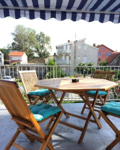 un tavolo e sedie di legno su un patio di ORA apartments a Donji Štoj