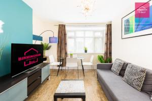a living room with a couch and a tv at Birmingham Contractor Stays - 3 Bedroom Flat, 6 Beds plus Parking in Birmingham