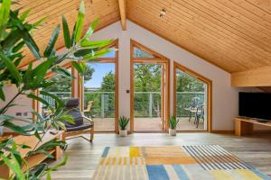 a living room with large windows and a flat screen tv at Everwyn Lodge - Luxury Lodge with Hot Tub in Penally