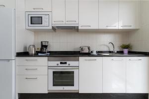a white kitchen with white cabinets and a sink at Apartamento Sussa 7B by HH in Tías
