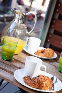 - une table avec deux assiettes de viennoiseries et une carafe de jus d'orange dans l'établissement Durlet Rambla Mar Apartments, à Barcelone