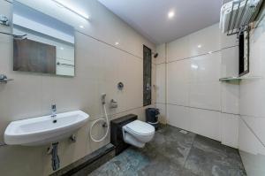 a bathroom with a toilet and a sink at Hotel Aatithya Satkar Near Mahalaxmi Temple in Kolhapur +27 photos