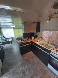 a large kitchen with a sink and a stove at Kemping Pod Topolami in Górkło
