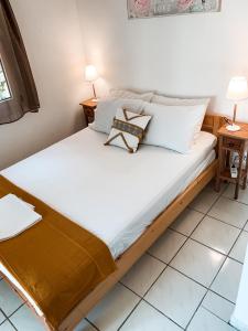 łóżko z białą pościelą i poduszkami w pokoju w obiekcie villa Hara w mieście Kanapitsa