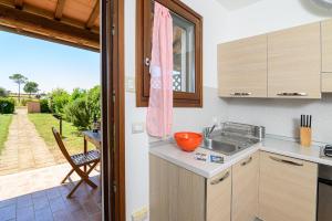 a kitchen with a counter with a sink and a table at Residenza Principina in Principina Terra