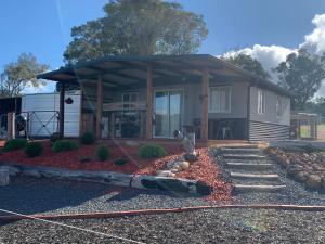 a house with a porch and a yard with rocks at Anahita Studio in Balingup