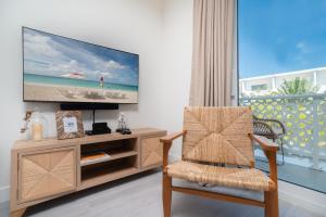 a living room with a tv and a chair at Luxury 1 bed apartment near Seven Mile Beach at The Grove - Villa Zen in Upper Land