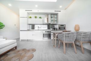 a kitchen with a table and chairs in a room at Luxury 1 bed apartment near Seven Mile Beach at The Grove - Villa Zen in Upper Land