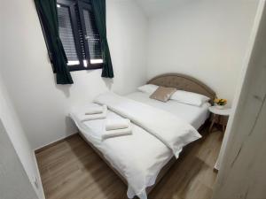 a bedroom with a bed with white sheets and a window at Cozy Home Kolasin in Kolašin