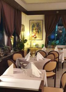 a restaurant with tables and chairs with white table cloth at Hotel garni Bad Café Bad Niedernau in Bad Niedernau