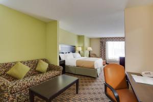 a hotel room with a bed and a couch at Holiday Inn Statesboro-University Area by IHG in Statesboro +33 photos