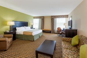 a hotel room with a bed and a couch at Holiday Inn Statesboro-University Area by IHG in Statesboro
