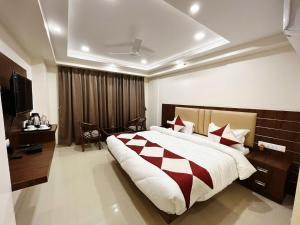 a bedroom with a large bed and a television at Hotel MK Grand in Varanasi