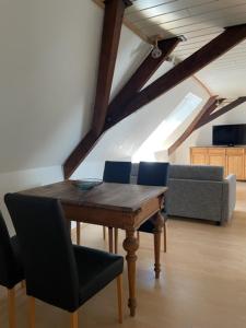 a room with a table and a couch in a attic at Landhaus Lindenbusch in Weseke